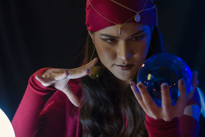 Female fortune teller with crystal ball at home