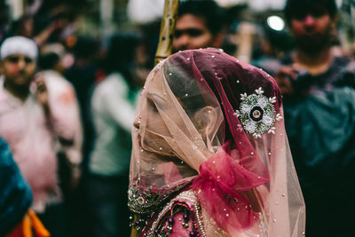 Close-up of woman with pink petals on background