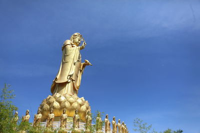 Low angle view of statue against blue sky