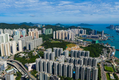 High angle view of city by sea against sky