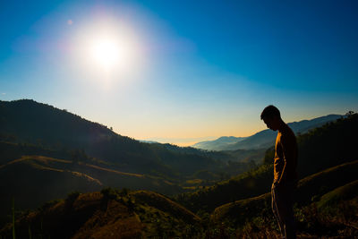 Man standing on mountain against sky