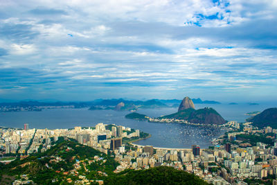 High angle view of city by sea against sky