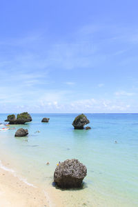 Scenic view of rocks in sea against sky