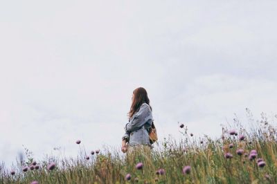 Purple flowers against woman standing on field