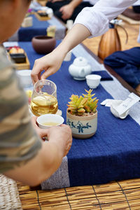 Midsection of woman holding ice cream on table