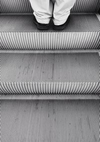 Low section of woman on escalator