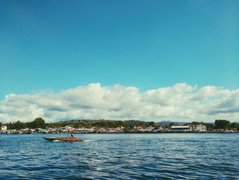 Scenic view of sea by buildings against sky
