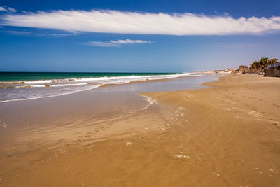 Scenic view of sea against blue sky on sunny day