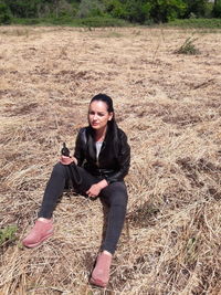 Portrait of smiling young woman sitting on land