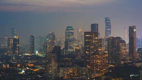 Illuminated cityscape against sky at night