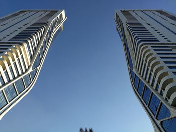 Low angle view of modern buildings against clear blue sky