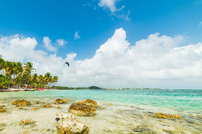 Scenic view of beach against cloudy sky