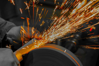 Cropped image of man using circular saw in workshop