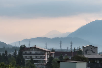 Houses and buildings against sky during sunset