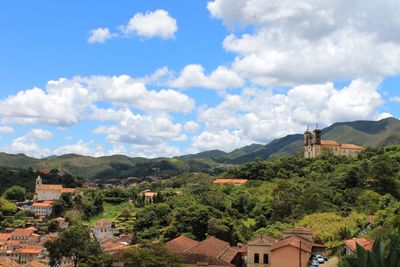 Houses in town by mountains against sky