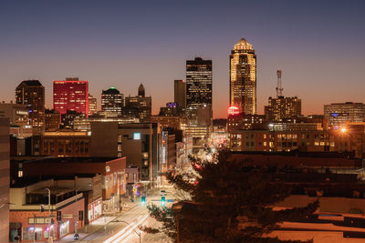 Illuminated buildings in city against sky at night