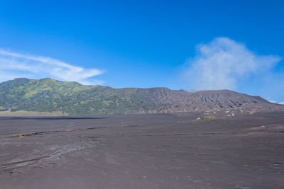 Scenic view of desert against blue sky