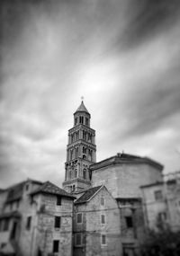 Low angle view of clock tower against cloudy sky