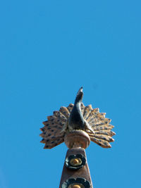 Low angle view of statue against clear blue sky