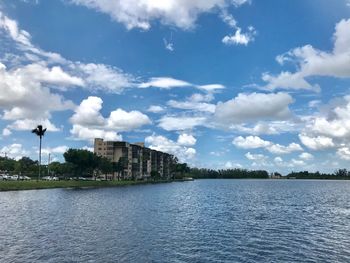 Scenic view of lake by buildings against sky