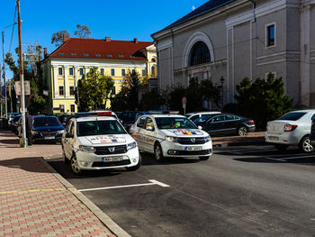 Cars on road by buildings in city