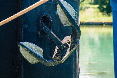 Close-up of rusty metal chain on lake