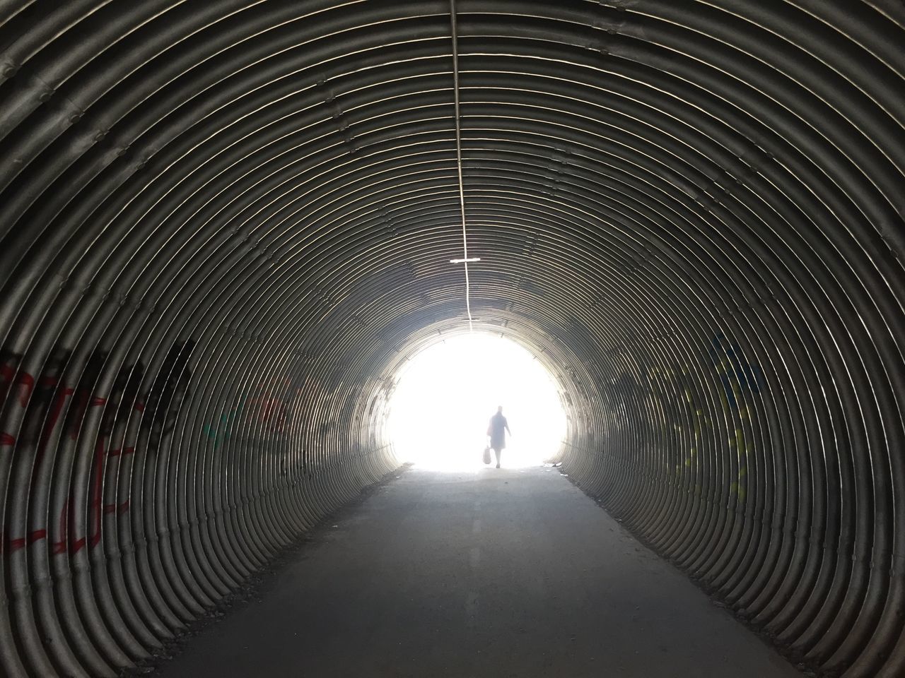 tunnel, the way forward, light at the end of the tunnel, one person, real people, walking, rear view, full length, indoors, architecture, built structure, day, people