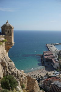 Buildings by sea against sky