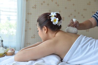 Midsection of woman relaxing on bed