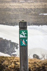 Information sign on wooden post by road