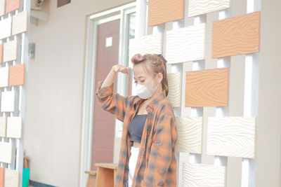 Portrait of smiling young woman standing at home