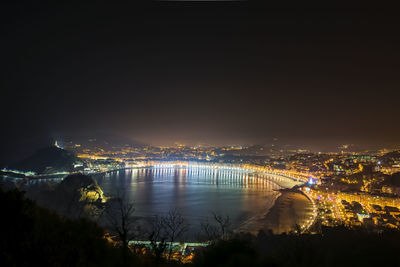 High angle view of illuminated cityscape against sky at night