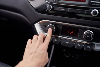 Cropped hand of man using mobile phone in car