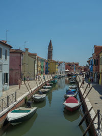 Boats moored on canal against buildings in city