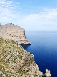 Rock formations by sea against sky