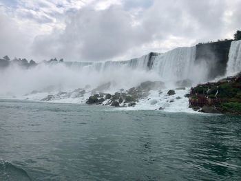 Scenic view of waterfall against sky