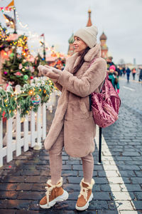 Full length of woman wearing hat on footpath