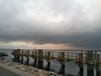 View of jetty leading to calm sea