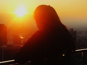 Rear view of silhouette man standing against sunset sky