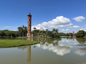 Lighthouse by lake against sky