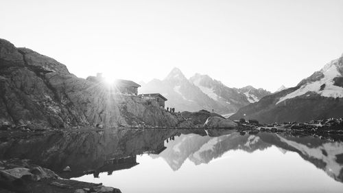 Scenic view of lake and mountains against clear sky in black and white 