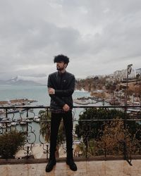 Full length of man standing by railing against sky