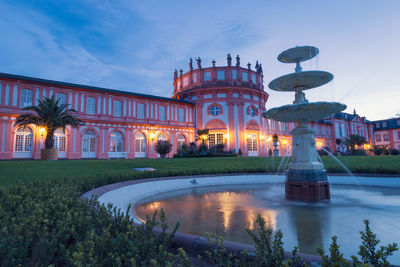 Biebrich castle in the german city of wiesbaden with water fountain at sunset against clear blue sky