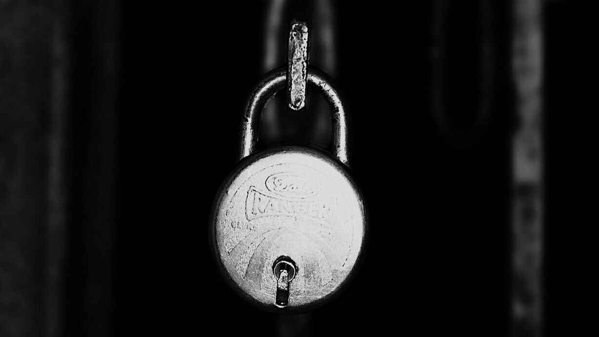 CLOSE-UP OF METAL HANGING ON BLACK BACKGROUND