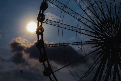 Low angle view of illuminated ferris wheel against sky at sunset