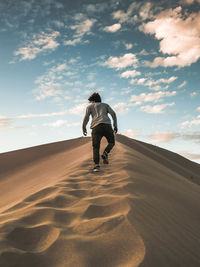 Rear view of man on sand dune