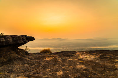 Rock formations on landscape against sky during sunset