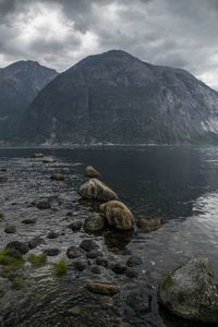 Rocks by lake against mountains