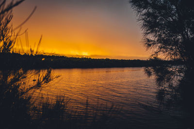 Scenic view of calm lake at sunset