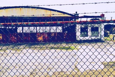 Close-up of chainlink fence against sky